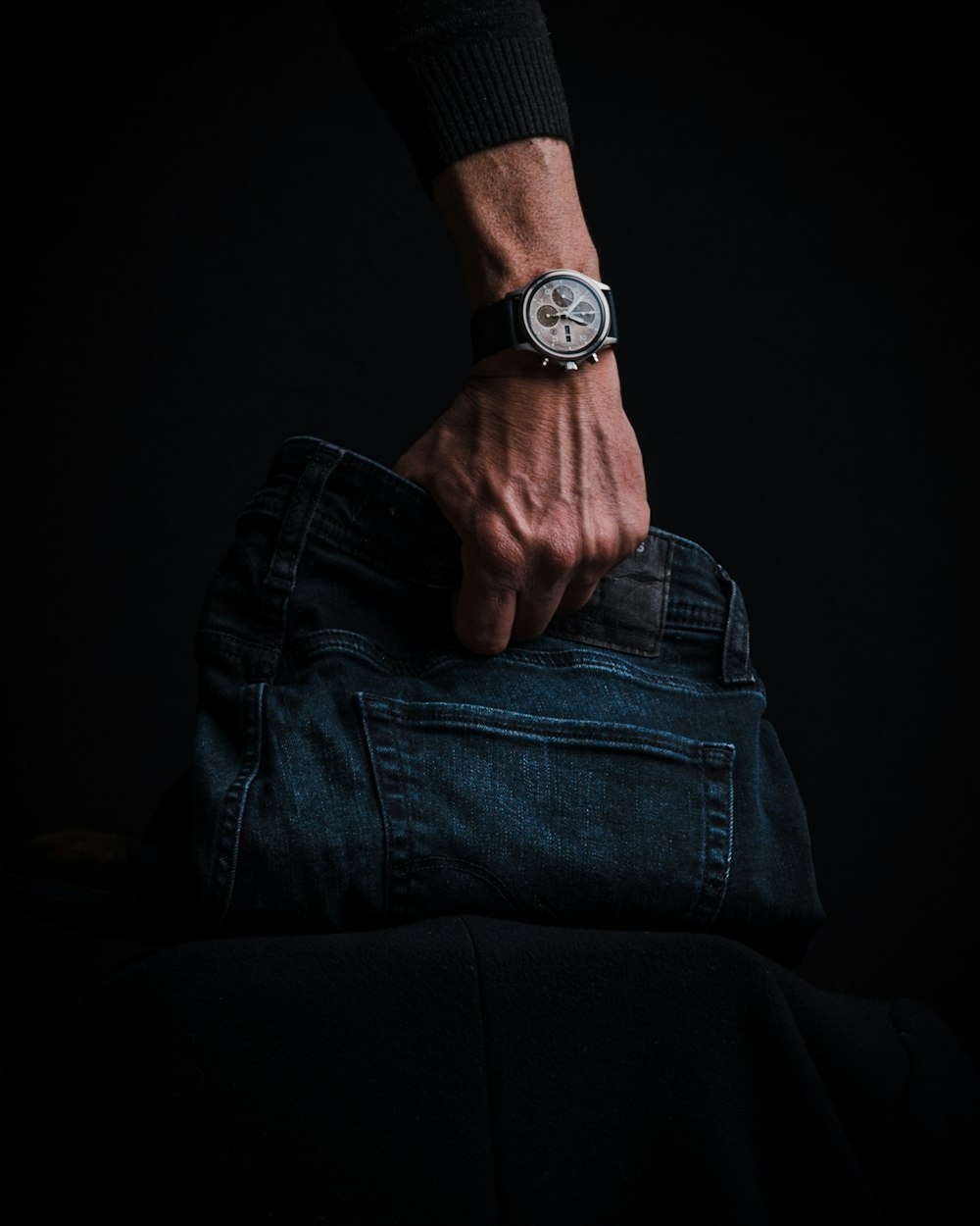 a person holding onto a pair of jeans