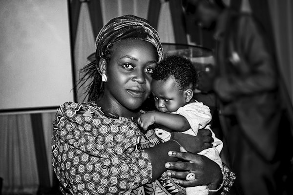 Black mother holding her baby outdoors, free and rooted