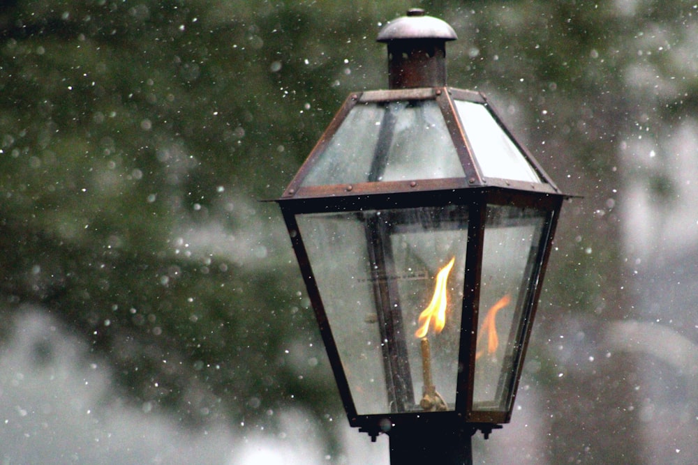 a lamp post with a lit candle on top of it