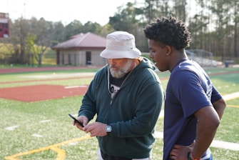 a man standing next to another man on a field