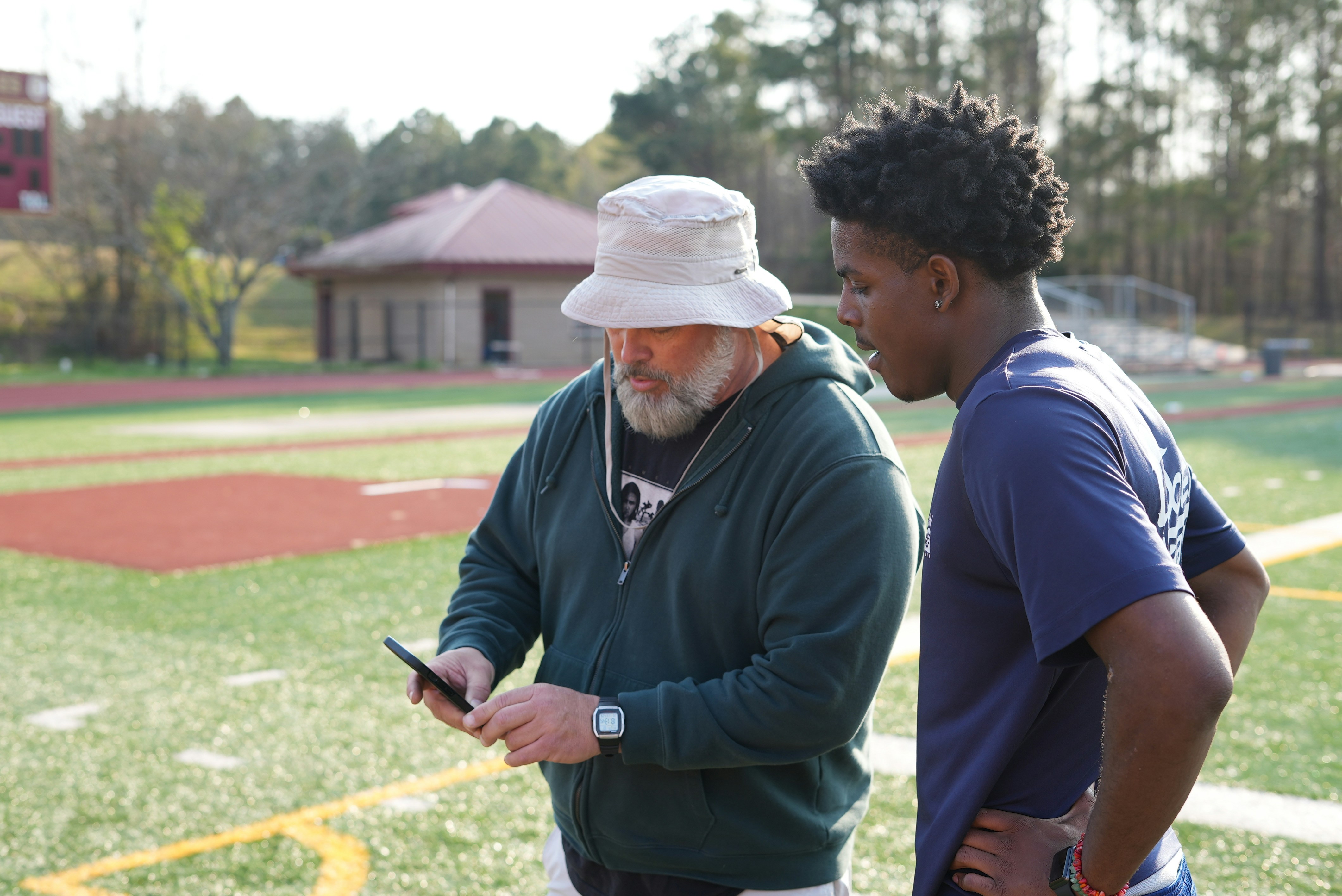 a man standing next to another man on a field