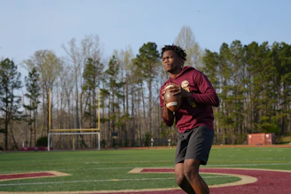 a man holding a football on a field