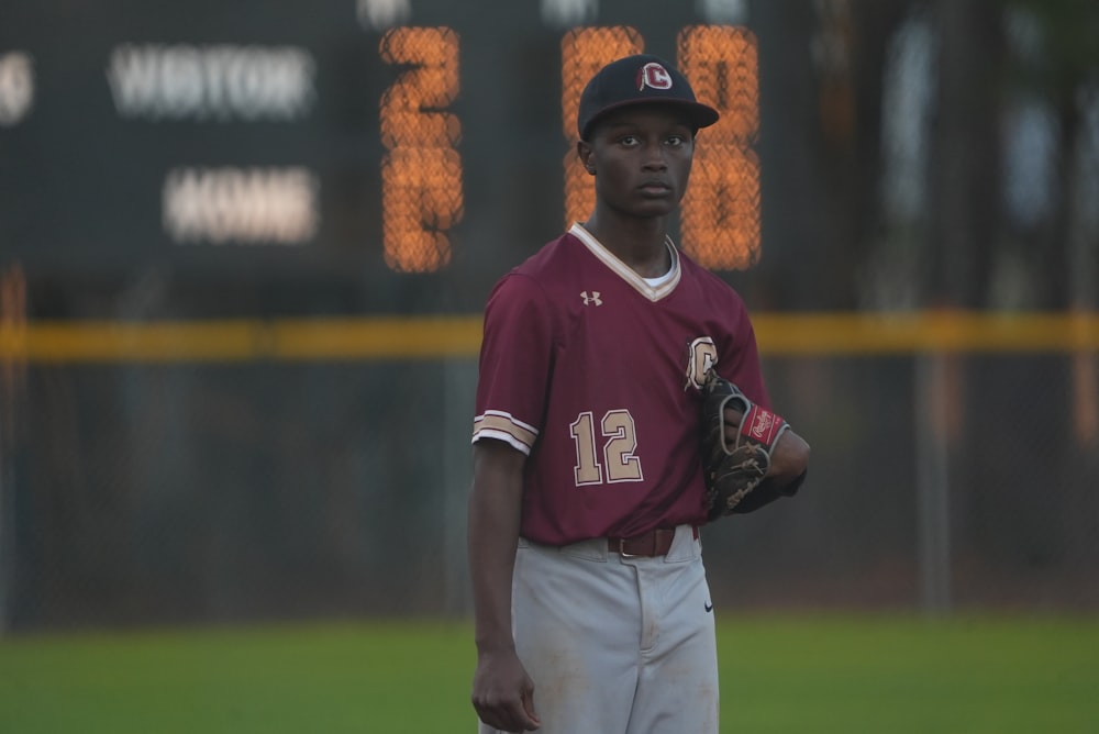 a baseball player standing on a field holding a glove