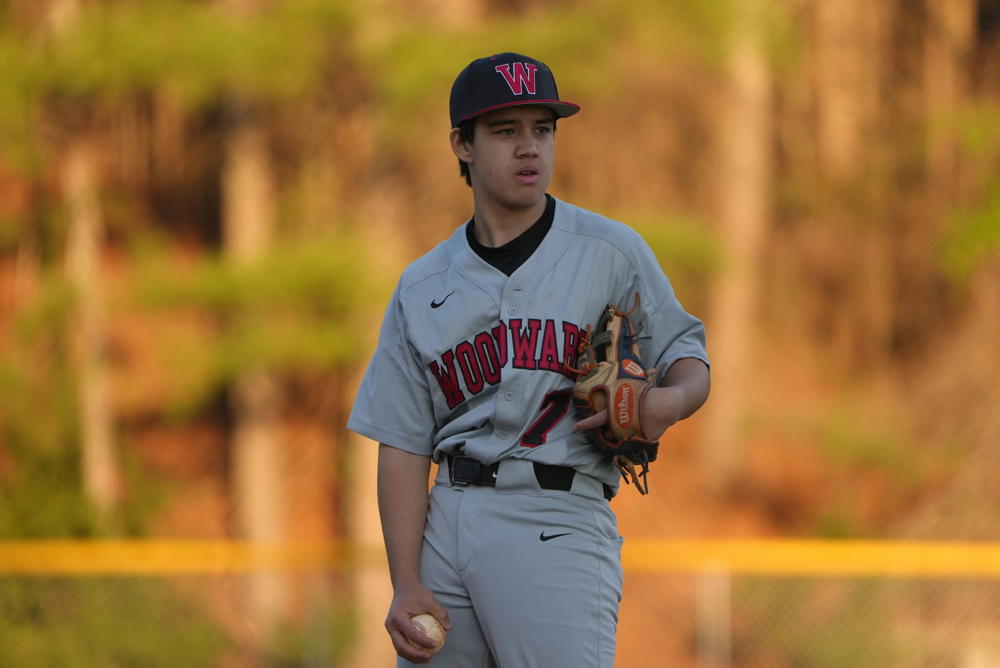a man in a baseball uniform holding a baseball