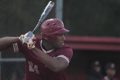 Close-up of a young player proudly holding a baseball bat ready to swing.