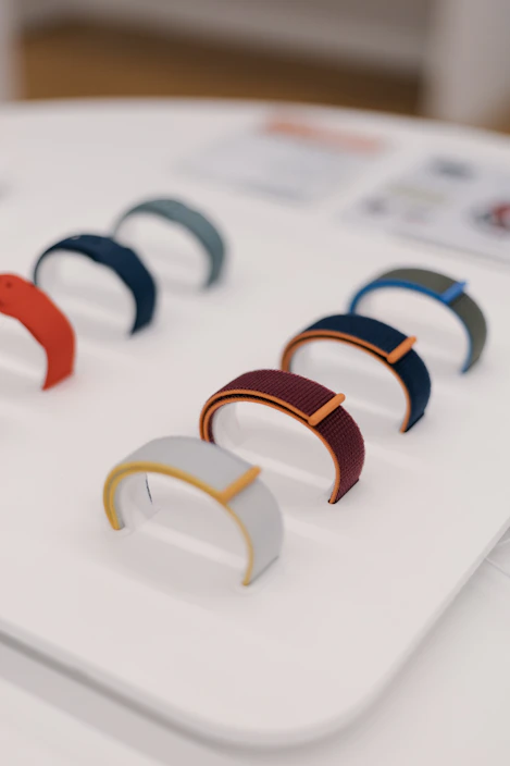 Close-up of colorful custom rubber wristbands stacked neatly on a wooden table.