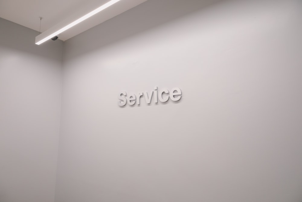 un mur blanc sur lequel est écrit le mot service