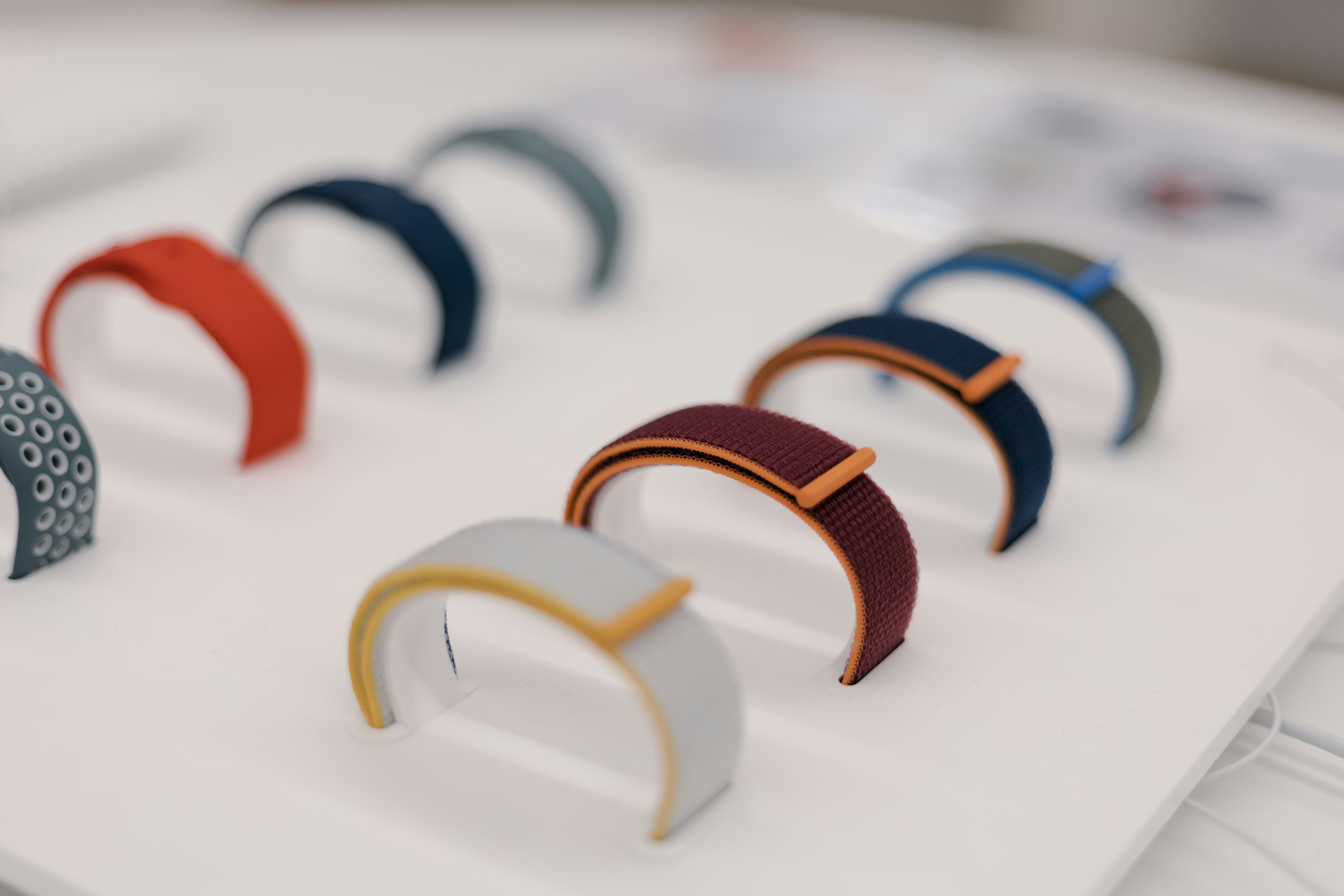 A collection of colored smart watch bands arranged on a table — wearable technology options for longevity monitoring