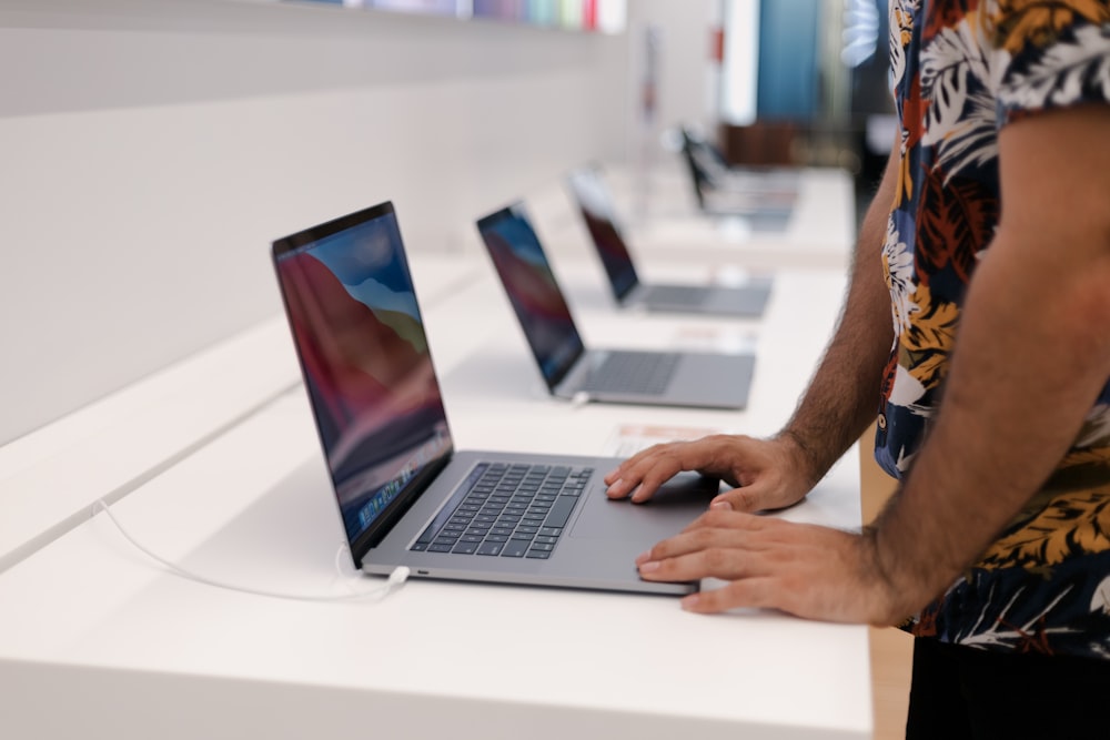 um homem está usando um laptop em uma mesa