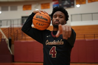 a man holding a basketball in a gym