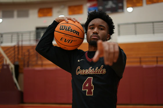 a man holding a basketball in a gym