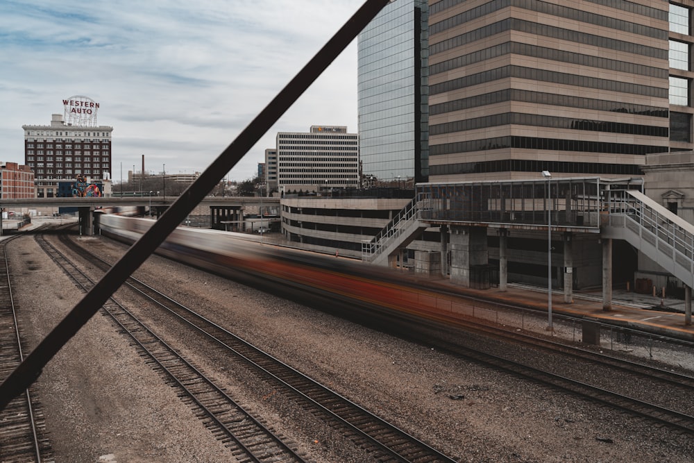 a train traveling past a tall building next to train tracks