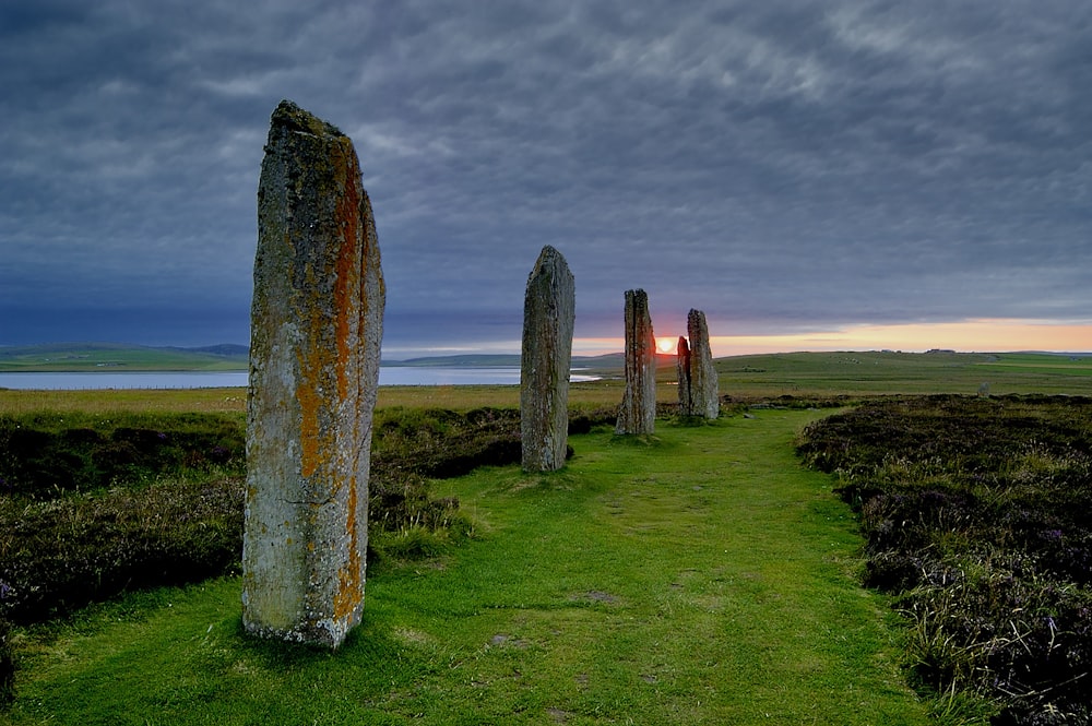 a group of large rocks sitting on top of a lush green field