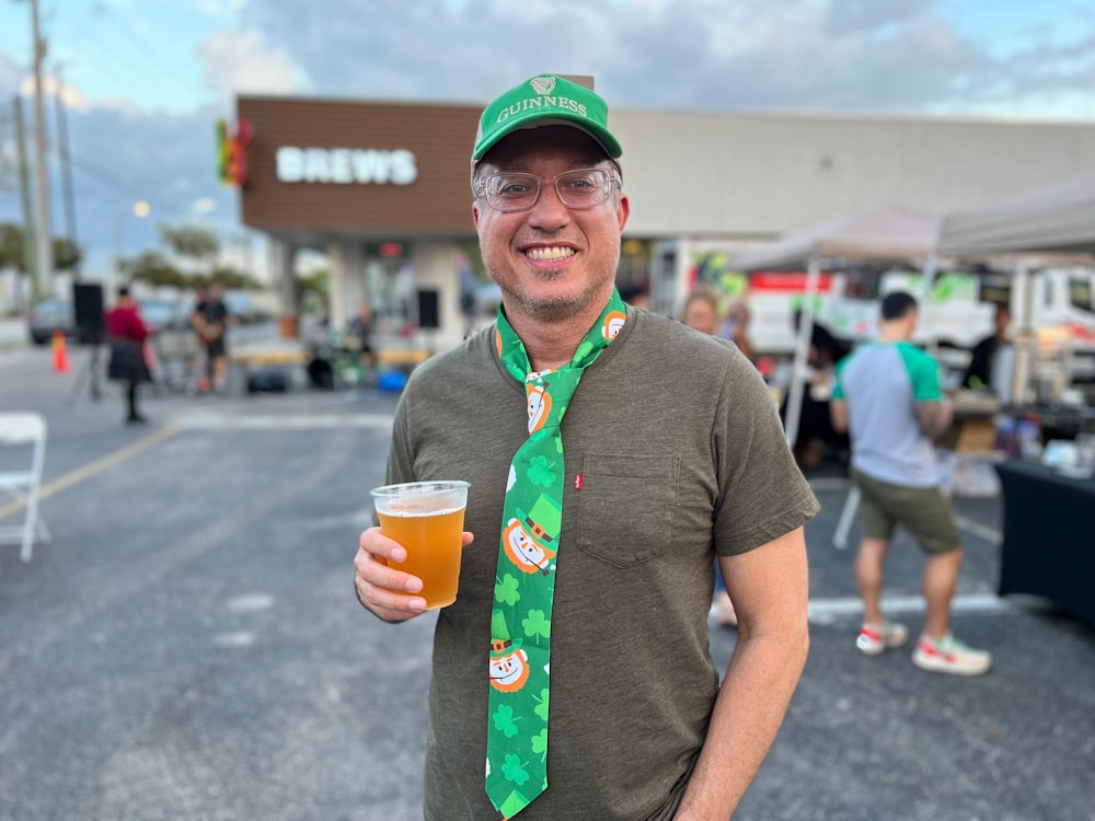 a man wearing a green tie and a st patrick's day hat holding a