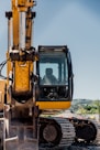 a yellow and black construction vehicle on a dirt road