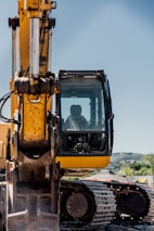 a yellow and black construction vehicle on a dirt road