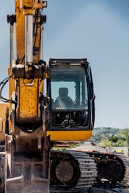 a yellow and black construction vehicle on a dirt road