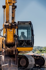 a yellow and black construction vehicle on a dirt road