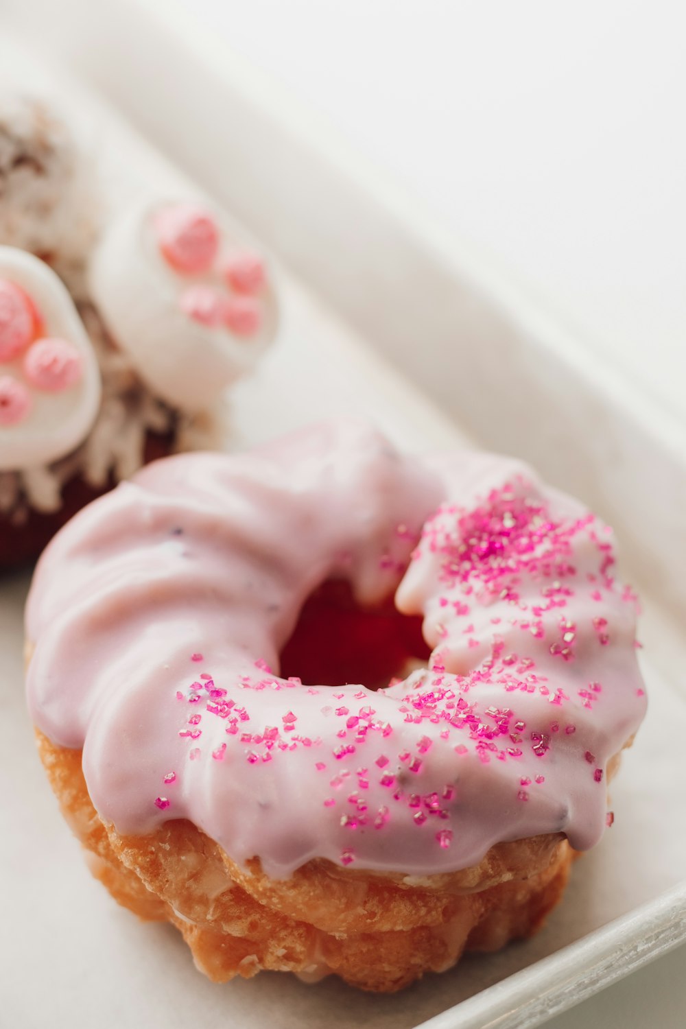 a close up of a doughnut with pink sprinkles