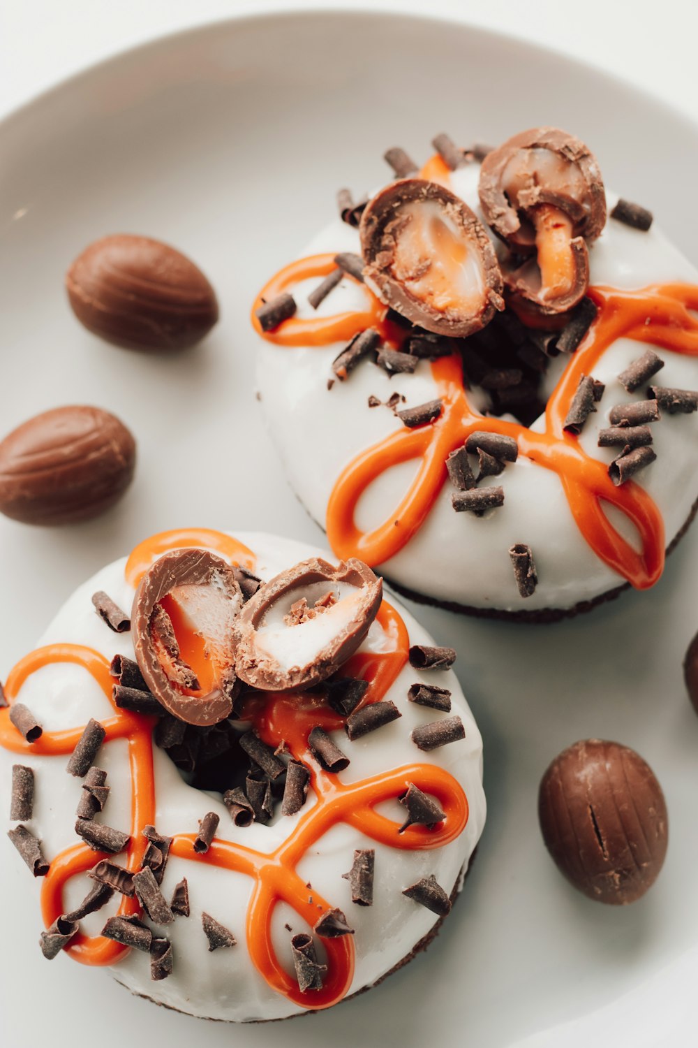 a white plate topped with two donuts covered in frosting