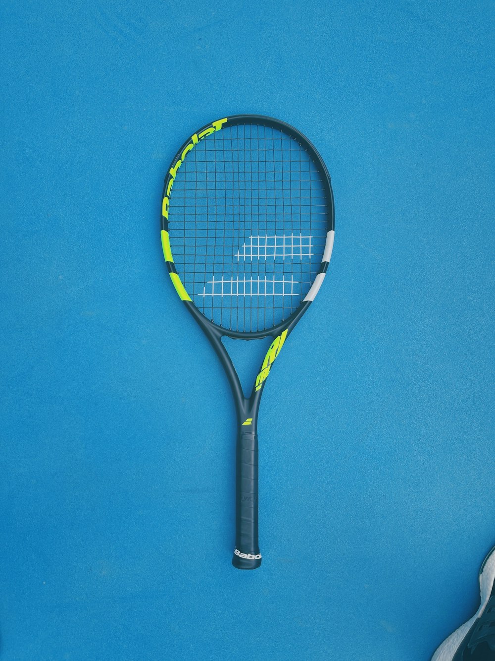 a tennis racquet laying on a blue surface