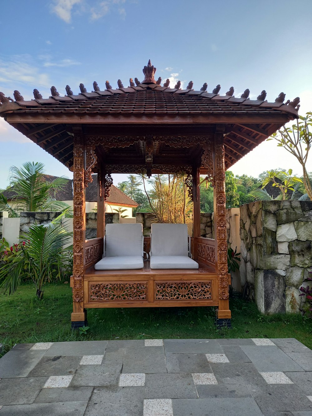 a wooden gazebo sitting on top of a lush green field