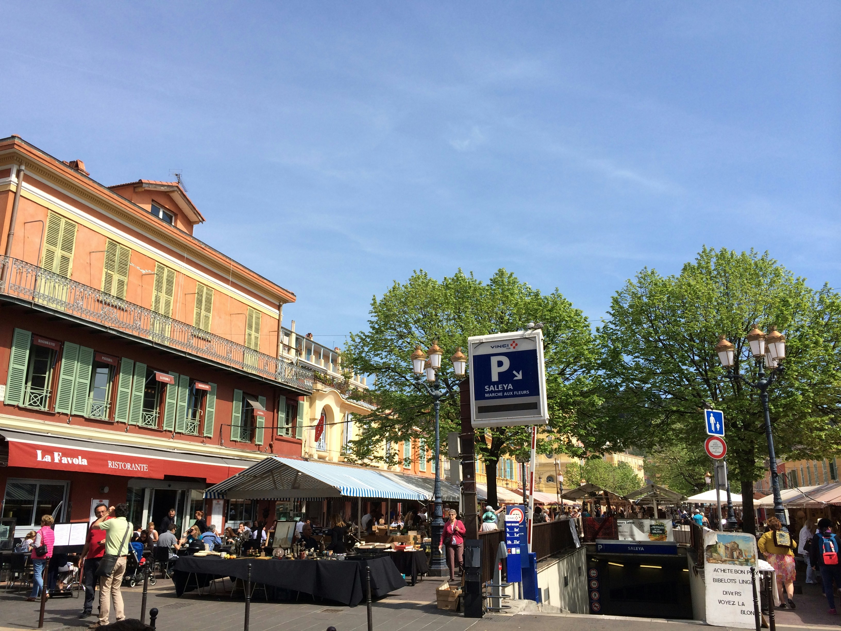 a group of people walking down a street next to tall buildings