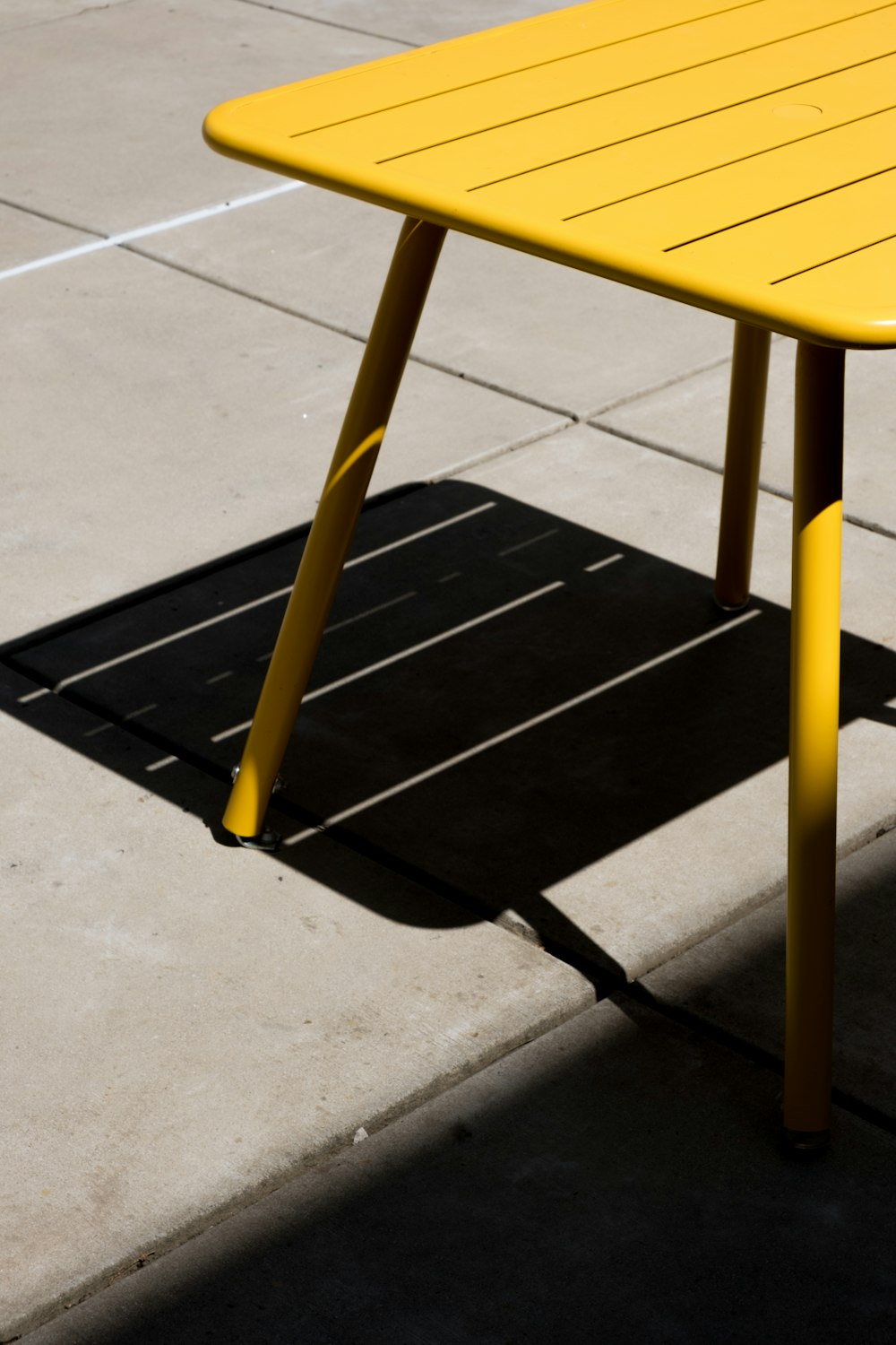 a yellow table sitting on top of a sidewalk