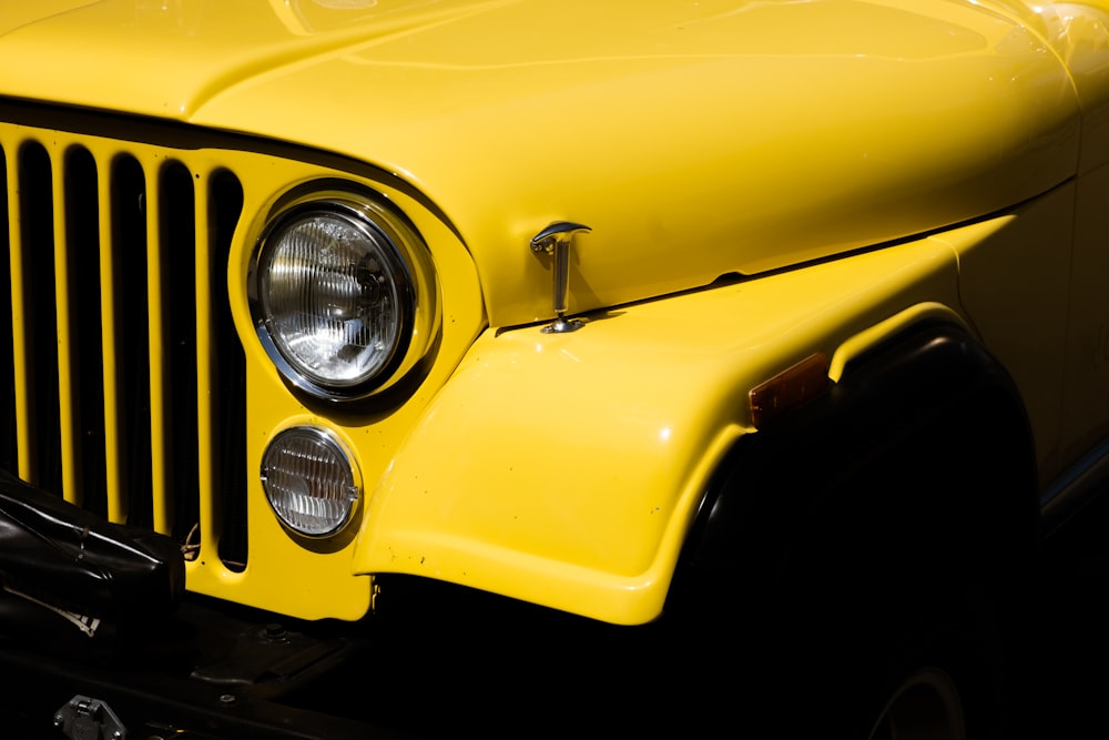 a close up of the front of a yellow jeep