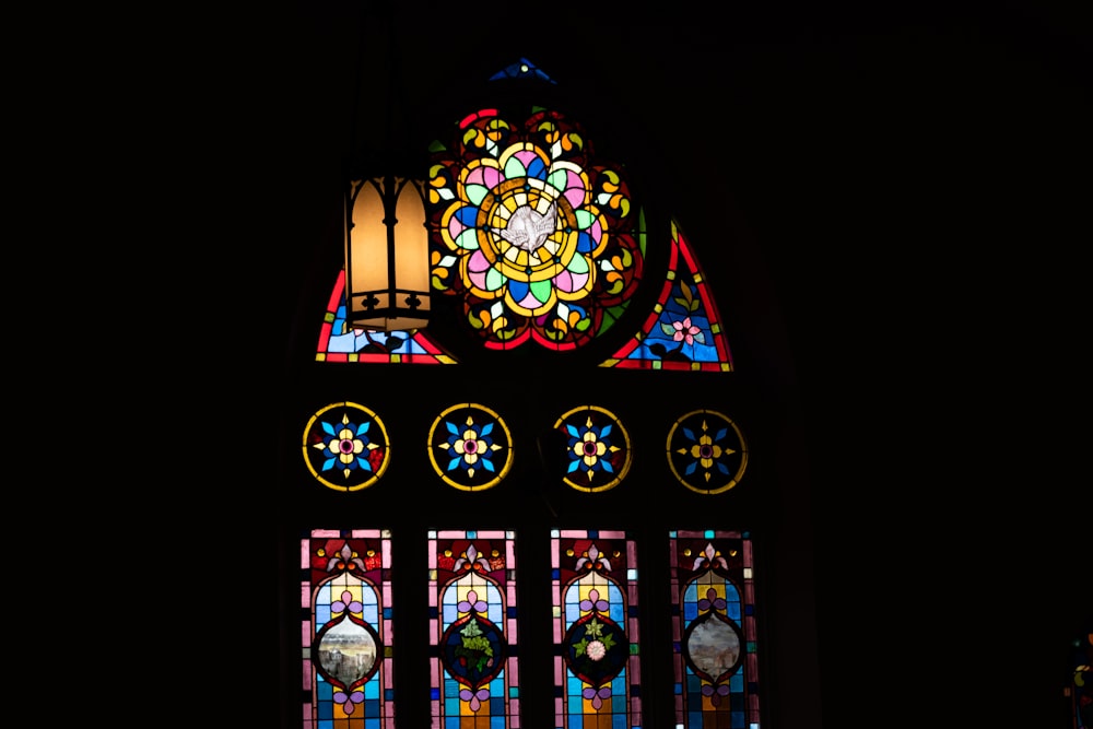 a large stained glass window in a dark room