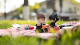 Two robots sharing a picnic blanket under a tree, with sandwiches and a vintage radio.