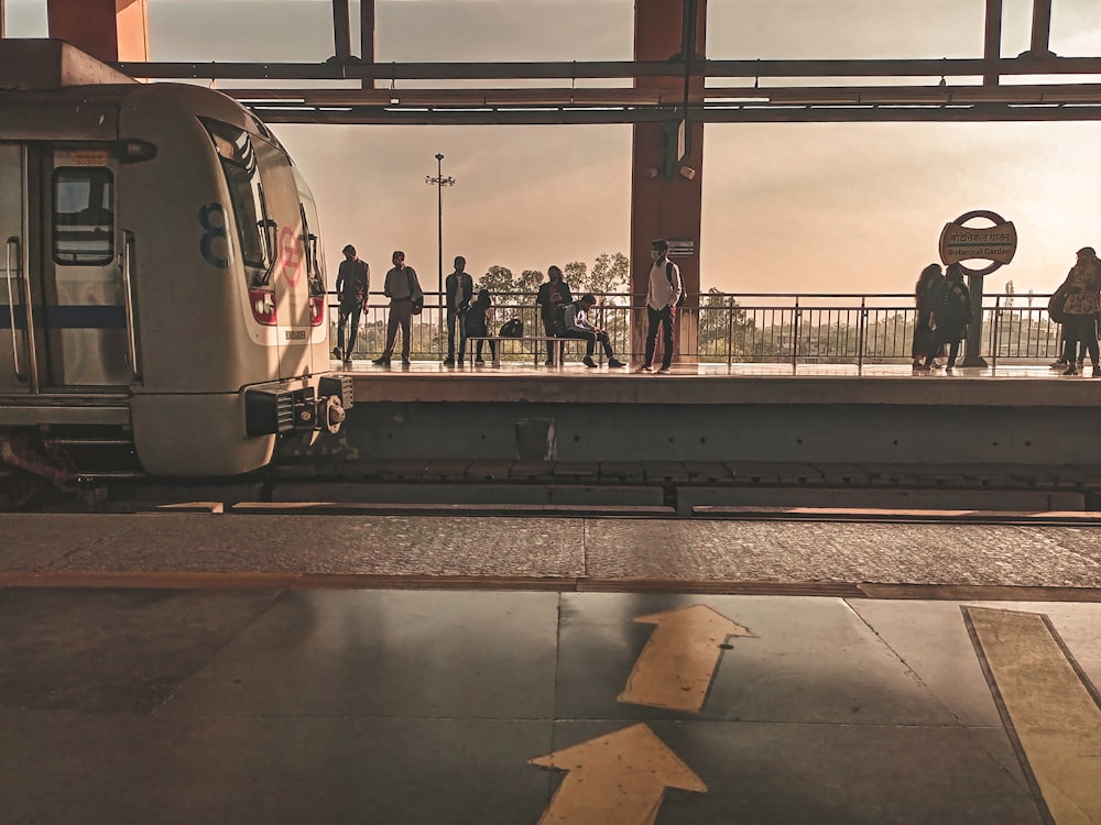 a group of people standing on a platform next to a train