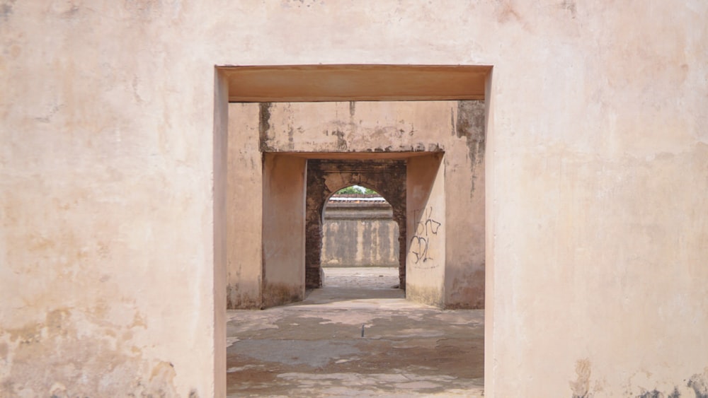 an open doorway in a wall with graffiti on it