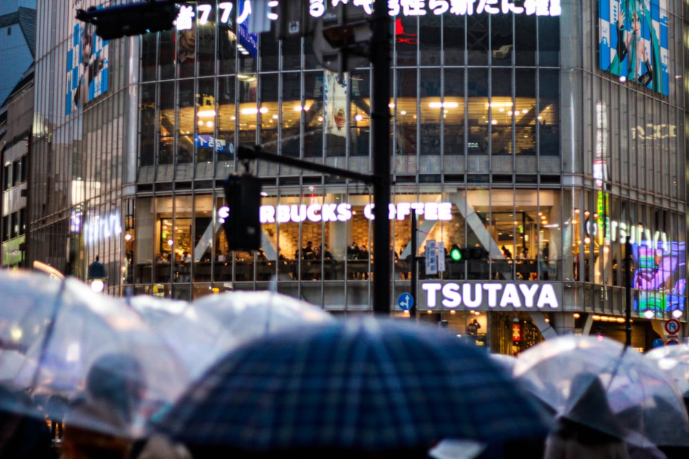 a group of people holding umbrellas in front of a building