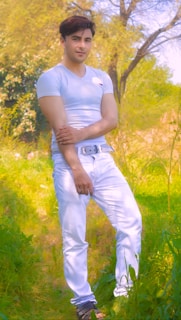 A model wearing a classic white t-shirt in a sunny outdoor setting.