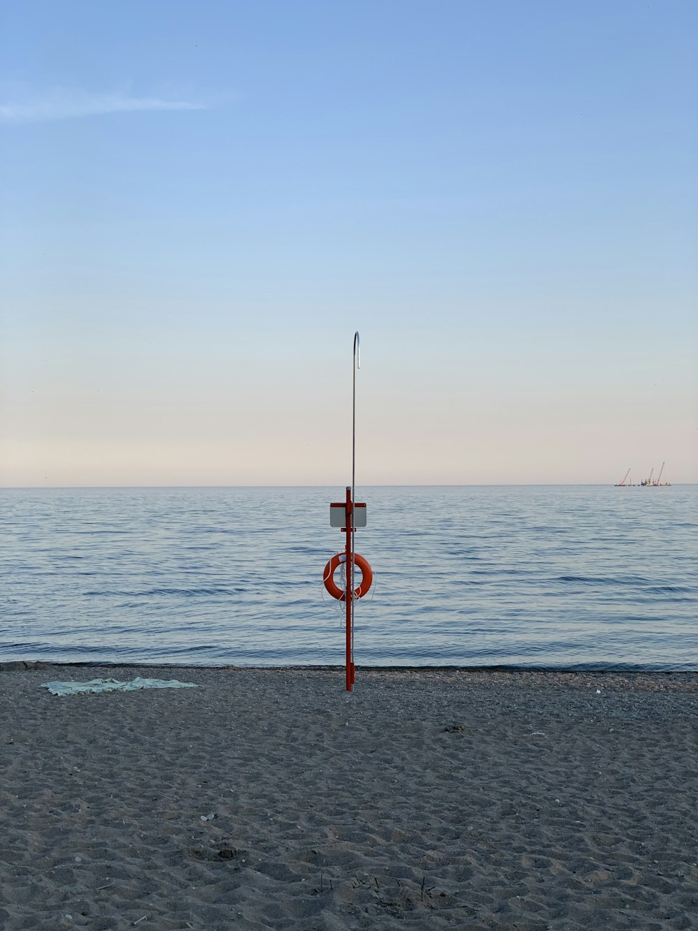 a pole on a beach with the ocean in the background