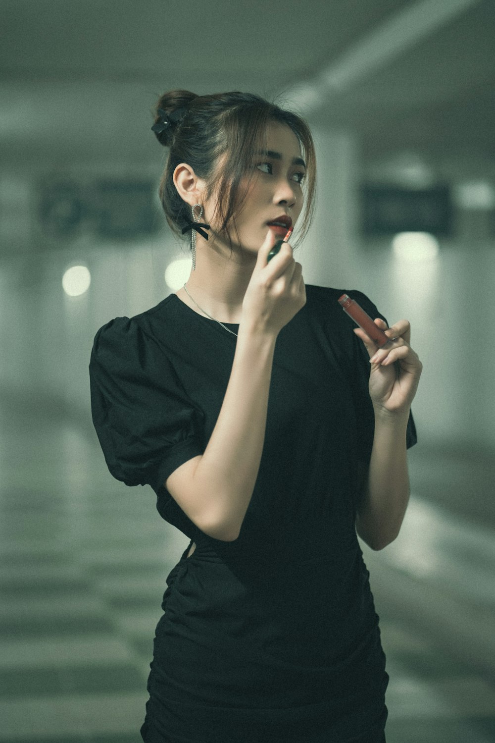 a woman in a black dress smoking a cigarette