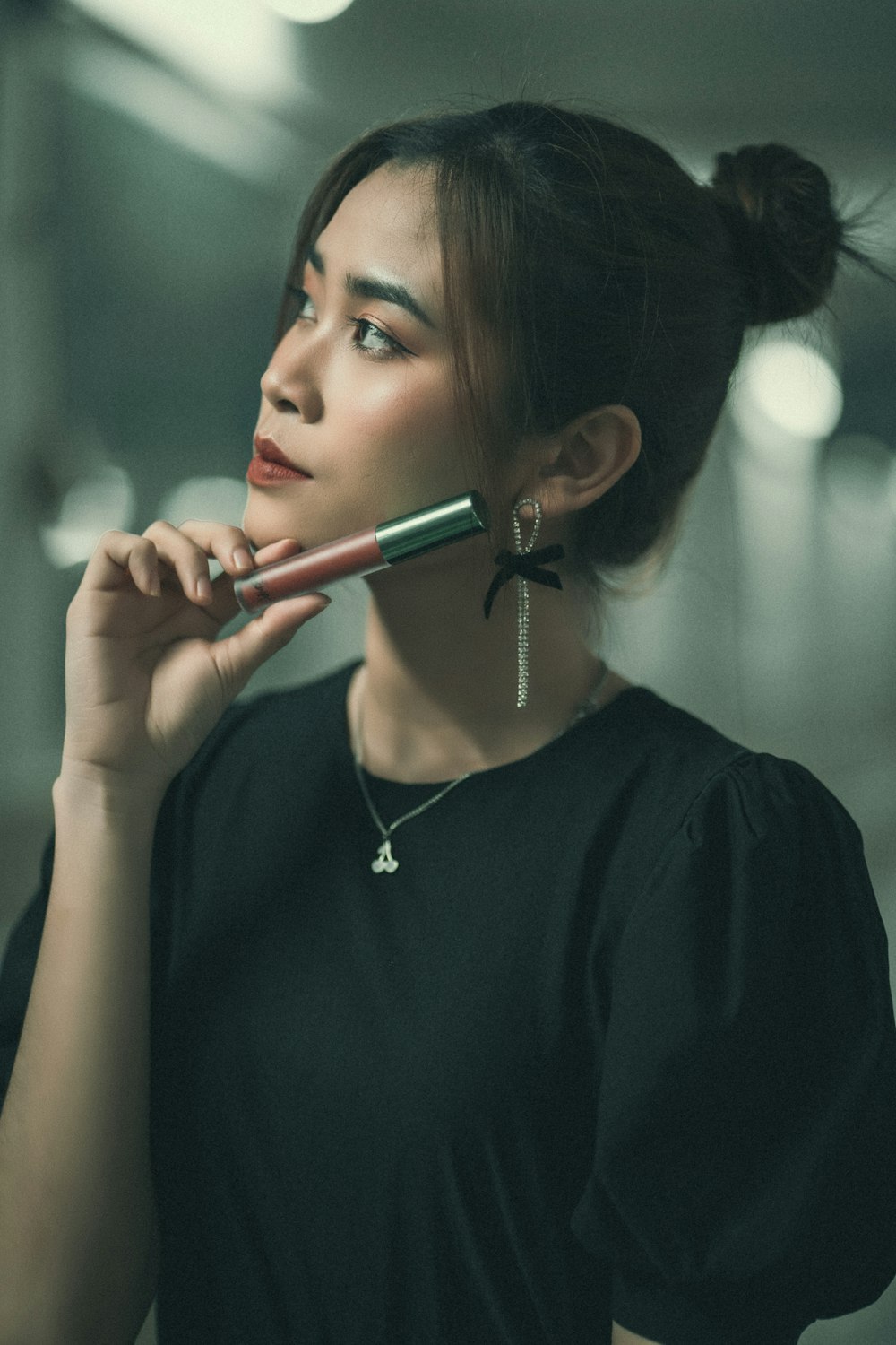 a woman holding a hair brush to her face