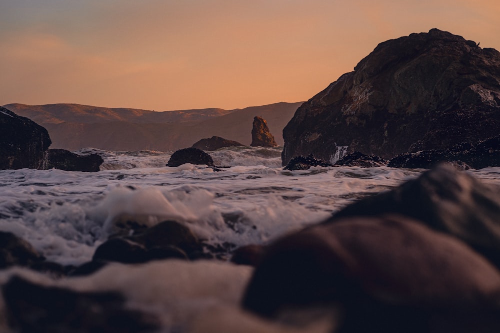 a large rock sitting in the middle of a body of water