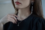 a woman wearing a pair of earrings and a black shirt