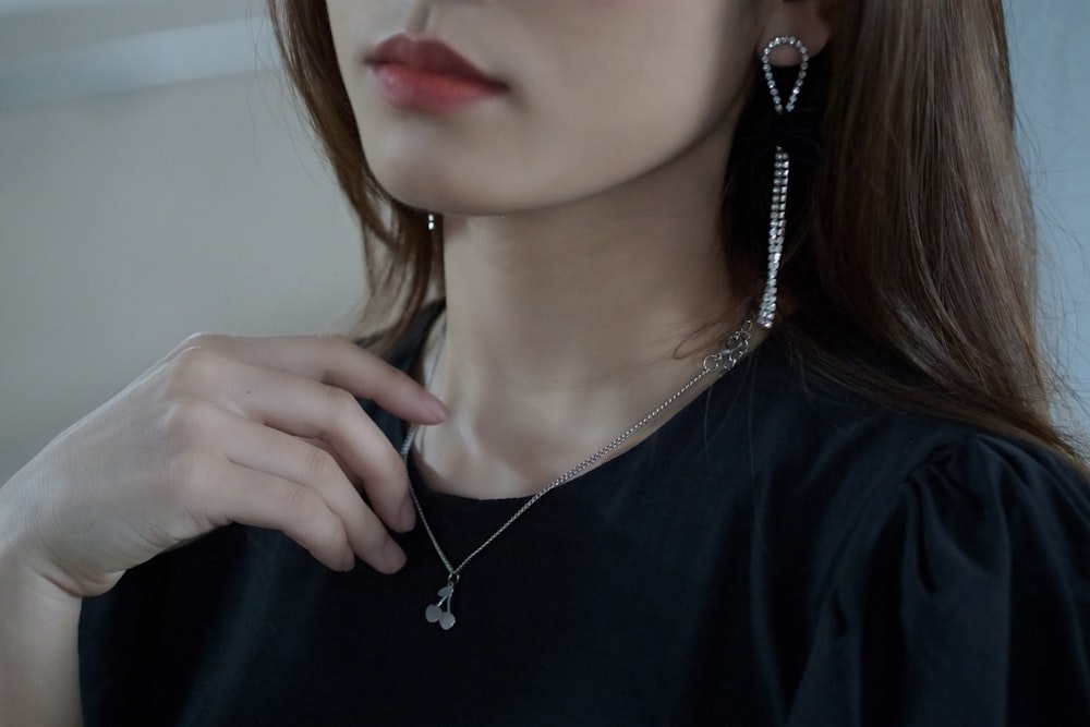 a woman wearing a pair of earrings and a black shirt