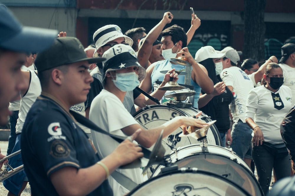 a group of people wearing face masks playing drums