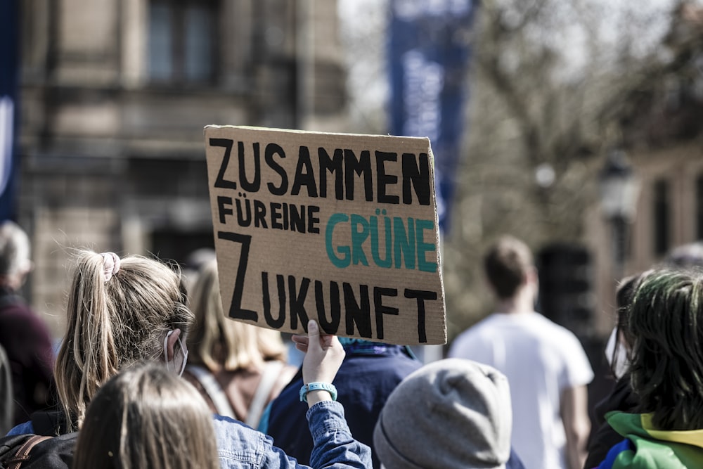 a person holding a sign in a crowd