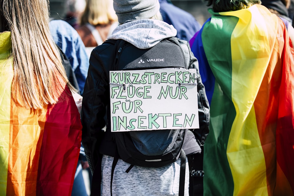 a group of people standing next to each other holding a sign