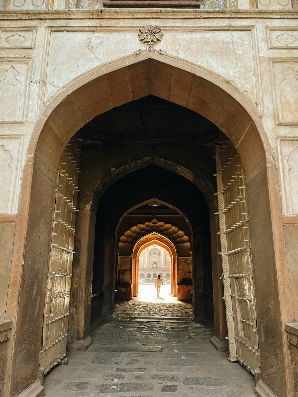 an archway leading into a building with a clock on the wall