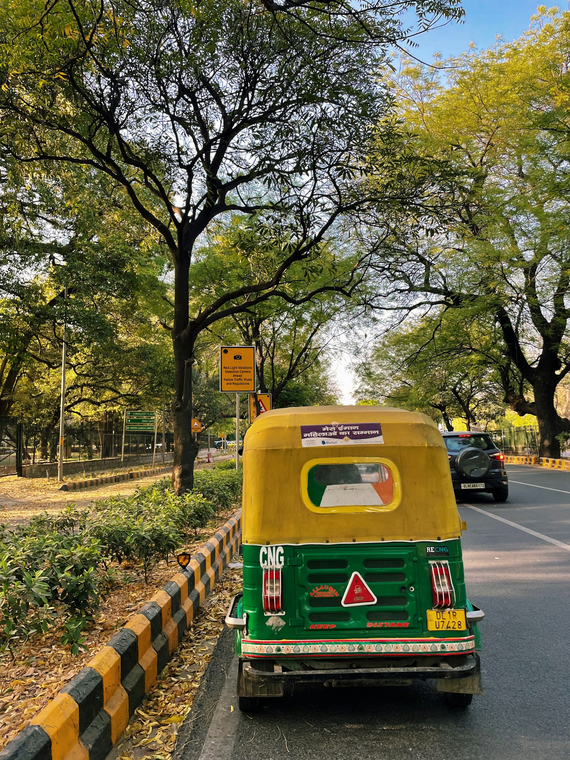 a green and yellow vehicle driving down a street