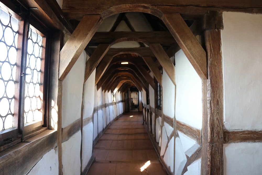 a long hallway with wooden beams and windows