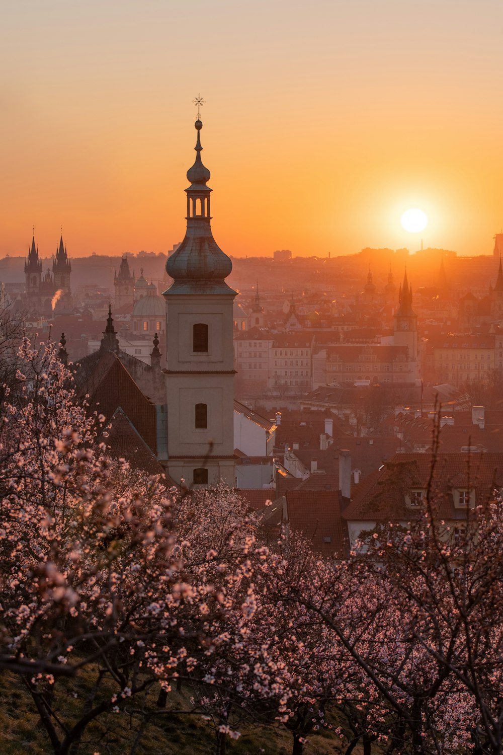 the sun is setting over the city of prague