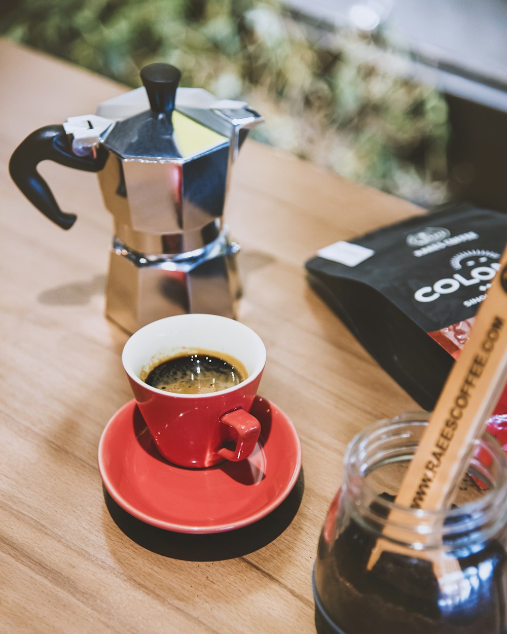 a cup of coffee sitting on top of a red saucer