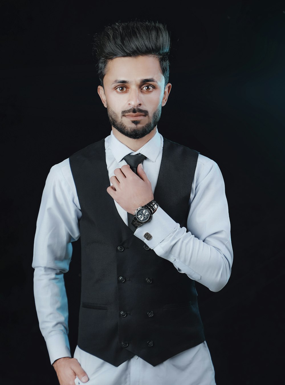 a man in a vest and tie posing for a picture